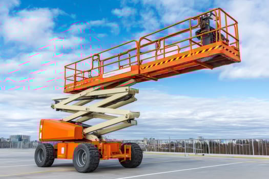Scissor lift parked on rooftop under cloudy sky awaiting operation photo
