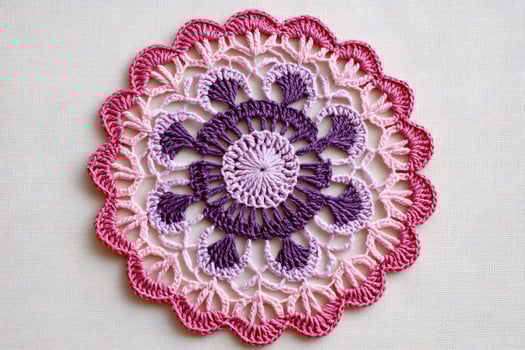 Beautiful pink and purple crochet doily showing delicate handmade craftsmanship photo