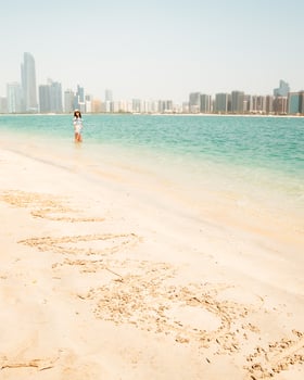 Happy young female tourist on viewpoint in hot day visiting Abu dhabi, UAE - Traveller girl taking portrait in front of capital skyline background. Urban middle east city life travel attractions. photo
