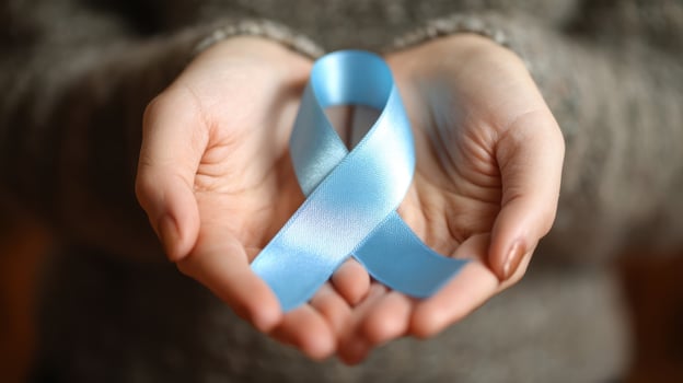 The blue awareness ribbon held in hands symbolizing support and solidarity. photo