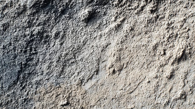 Textured surface featuring coarse aggregate and variations in color creates an abstract pattern photo