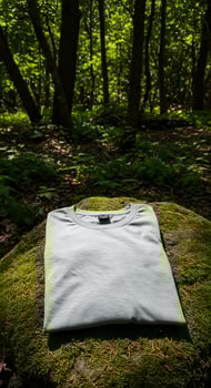 A t-shirt sitting on a moss covered rock photo