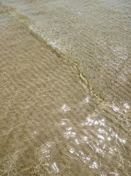 Glistening Ocean Waves on Sandy Shore. photo