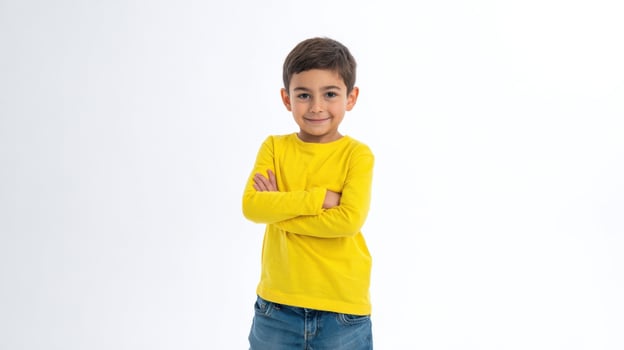 A young boy in a yellow shirt and jeans photo