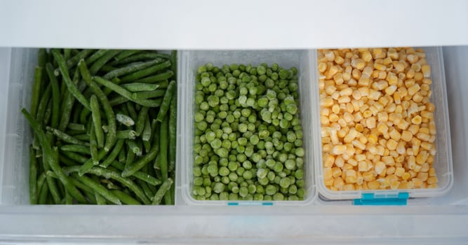 Frozen green beans, peas, and corn preserving freshness in refrigerator photo