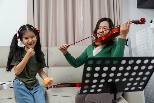 Learning Violin Together. Mother and daughter enjoying music at home. photo