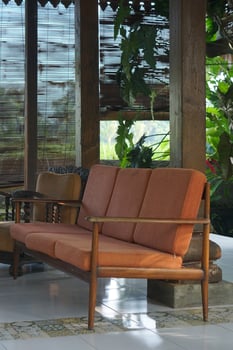 Vintage Sofa on Tiled Floor with Bamboo Screen and Lush Greenery View photo