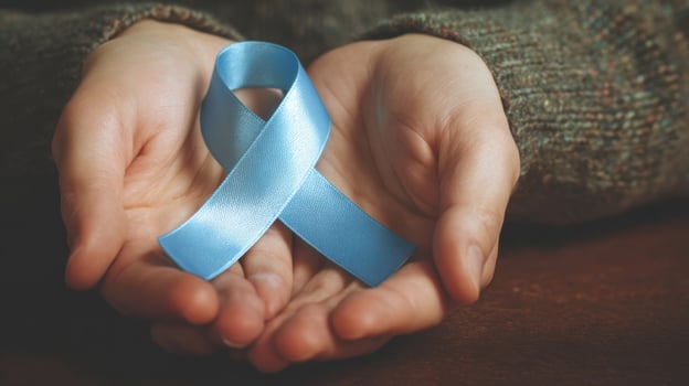 The beautiful blue ribbon symbolizing support and awareness held in gentle hands. photo
