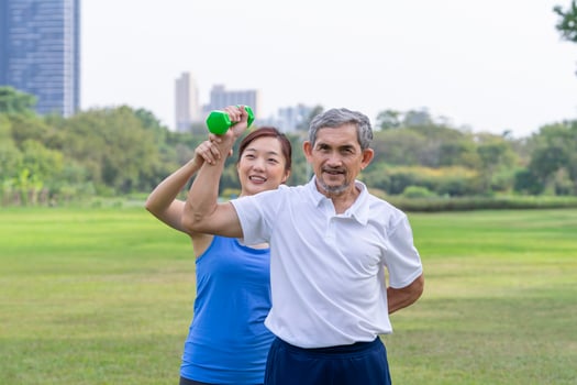 senior man doing exercise with dumbbell with trainer,elderly having physical activity in the park photo