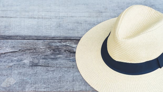 straw beach hat with black ribbon on the wooden seat whit free space, travel summer concept photo