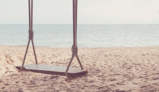 Close-up Rope wooden swing hanging on tree at topical beach with sunlight in Thailand photo