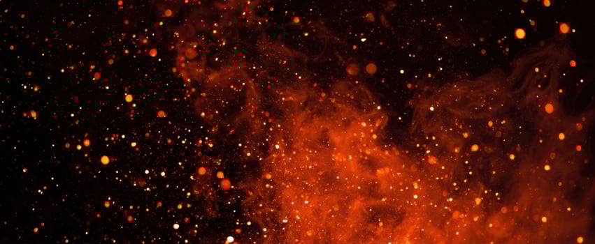 The vibrant explosion of fiery particles against a dark background. photo