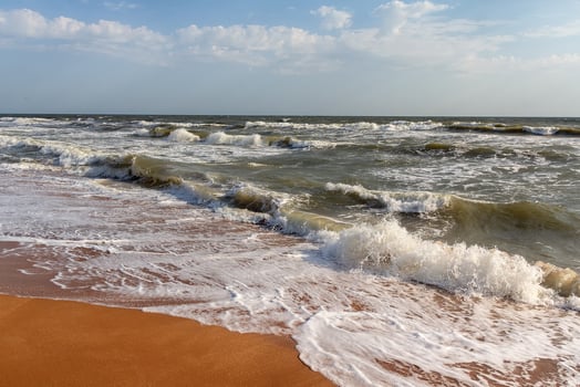 Soft wave gently washing golden sand on beach photo