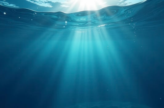 Sunlight piercing through ocean surface creating beautiful underwater beams photo