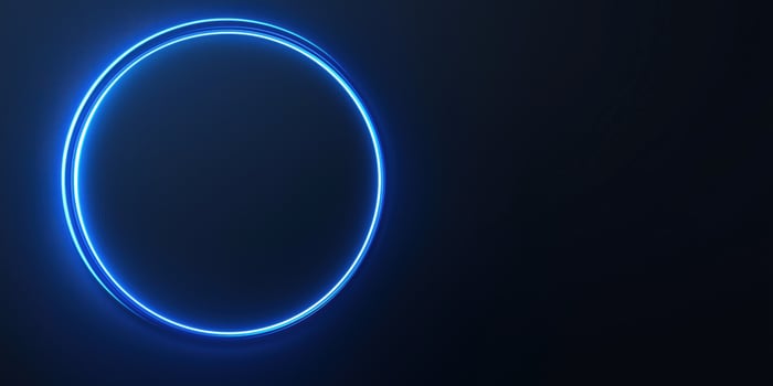 Bright neon blue circle glowing on dark background photo