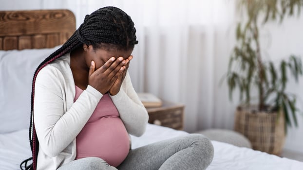 Sad Black Pregnant Woman Crying At Home, Having Maternity Depression, Suffering Hormonal Changes During Pregnancy, Desperate Lady Sitting On Bed In White Bedroom Covering Face With Hands, Copy Space photo