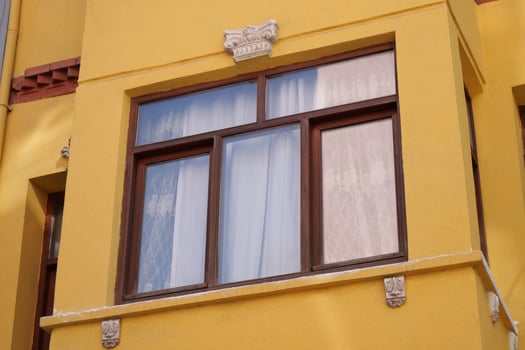 Decorative windows on a bright yellow building exterior photo