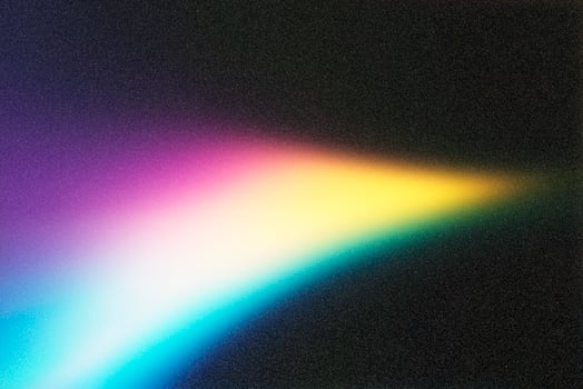 Colorful light beam shining through prism on black background photo