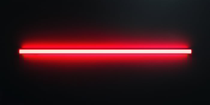 Red neon light tube shining on black background photo