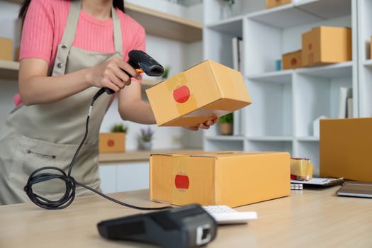 Small Business Efficiency. Female entrepreneur scanning packages for inventory management. photo