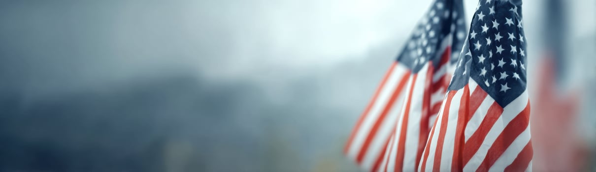 Two American Flags Stand Proudly Against a Pale Blue Gray Backdrop photo