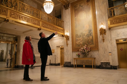 Tourists admire historical artwork in an elegant lobby during an evening visit to a luxurious building photo