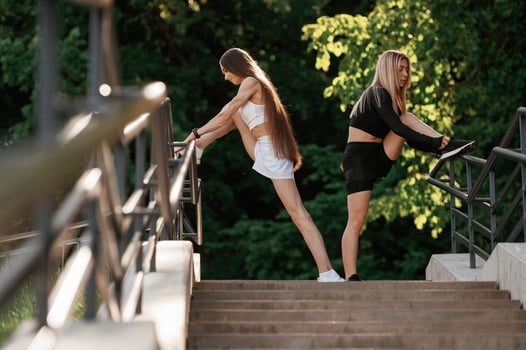 Railings and stairs. Two sportive women are outdoors together. photo