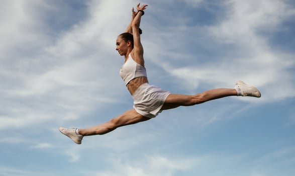 Blue sk,y with clouds, jumping. .Young skinny fitness woman is outdoors photo