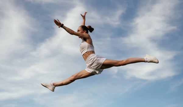 Blue, sky, with ,,clouds, jumping. Young skinny fitness woman is outdoors photo