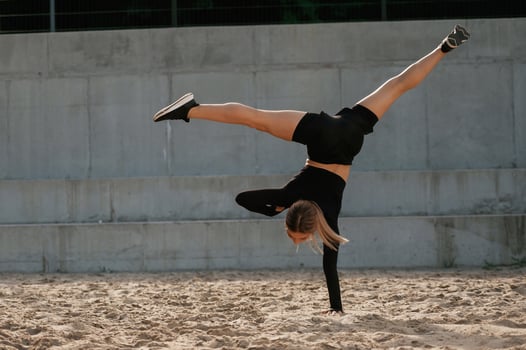 Doing tricks.. Beautiful fitness woman in sport clothes is outdoors photo