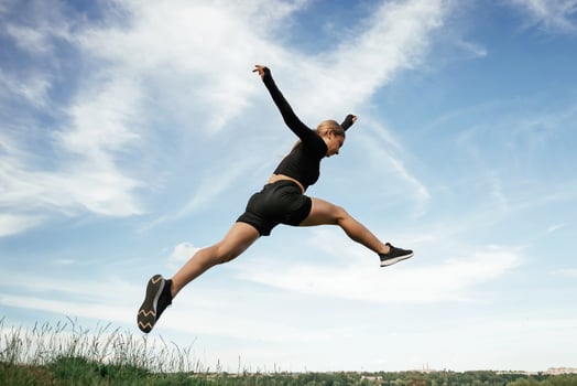 Jumping, against, the sky. Beautiful fitness woman in sport clothes is outdoors photo