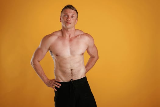 Shirtless,,, standing. Man, is ,against background in the studio photo