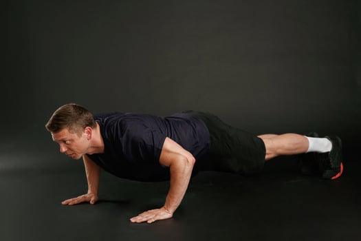 Push ,,ups exercise. Man is against background in the studio photo
