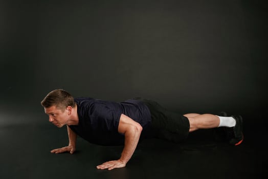 Push ,ups exercise. Man is against background in the studio photo