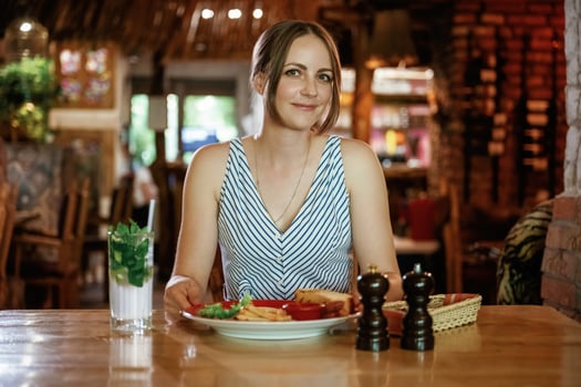 Front, view. Woman is in the restaurant with food and drink photo