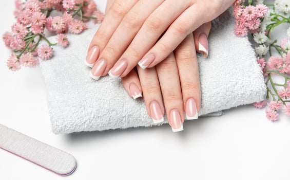 Woman showing her french manicure on a white towel photo