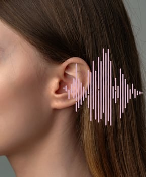 Close-up of a woman's ear alongside a sound wave illustration demonstrating audio perception photo