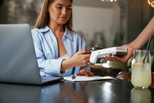 Using ,smartphone. Woman is paying for the service in the restaurant photo