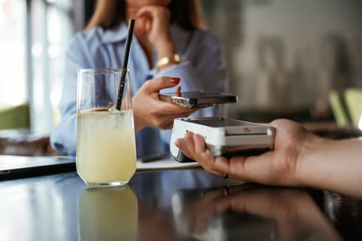 Contactless transfer. Woman is paying,, for the service in the restaurant photo