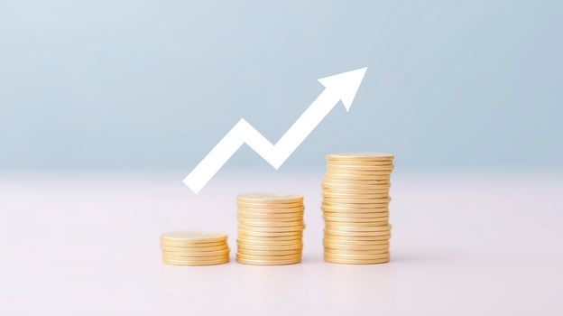 Stacks of golden coins arranged in ascending order with a white upward arrow symbolizing financial growth and success against a soft blue background, representing investment and prosperity photo