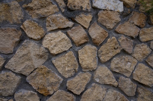 Close-up of a natural stone wall in Cyprus, showing rustic texture and warm colors, perfect as a background or design element. photo