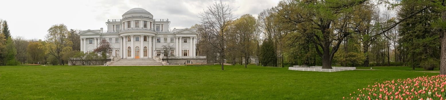 Elegant Historic Mansion Surrounded by Vibrant Gardens and Lush Greenery in Early Spring photo