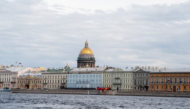 Picturesque Waterfront View of St. Petersburg Showcasing Historic Architecture and the Iconic Golden Dome Under a Cloudy Sky photo