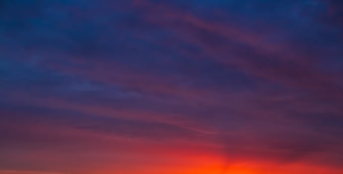 Evening sky with deep purple and orange hues against the setting sun photo