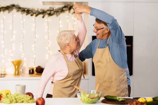Mature Married Couple Dancing In Kitchen, Having Fun Cooking Together On Christmas Eve. Senior Spouses Enjoying New Year Dinner Preparation At Home. Family Cooks Meal On Winter Holidays Indoors photo