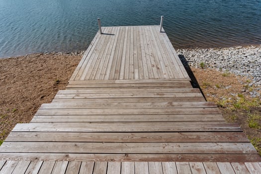A beautifully crafted wooden dock that extends out towards a serene body of water, providing a scenic pathway for visitors to enjoy the natural surroundings and take in the calming views photo