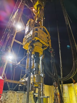 Close up of heavy drilling equipment working on industrial site at night. Oil production. Mobile photo