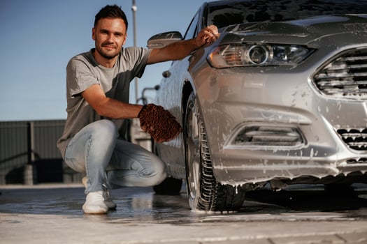 Sitting and washing, the, automobile. Man is with his car outdoors photo