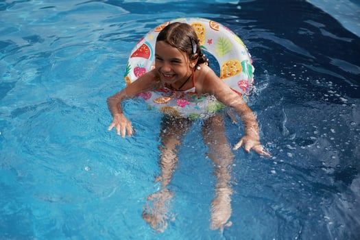 With ,lifebuoy, learning how to swim. Happy little girl is having fun in the pool photo