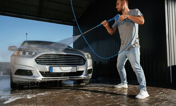 Standing ,and, washing the automobile. Man is with his car outdoors photo